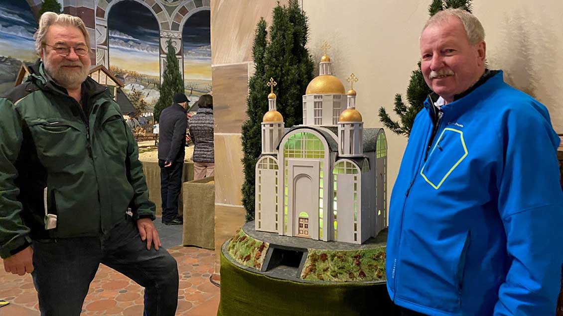 Die Krippenbauer Peter Kruszona (links) und Günter Drax zeigen das Modell der Kirche von Butscha.