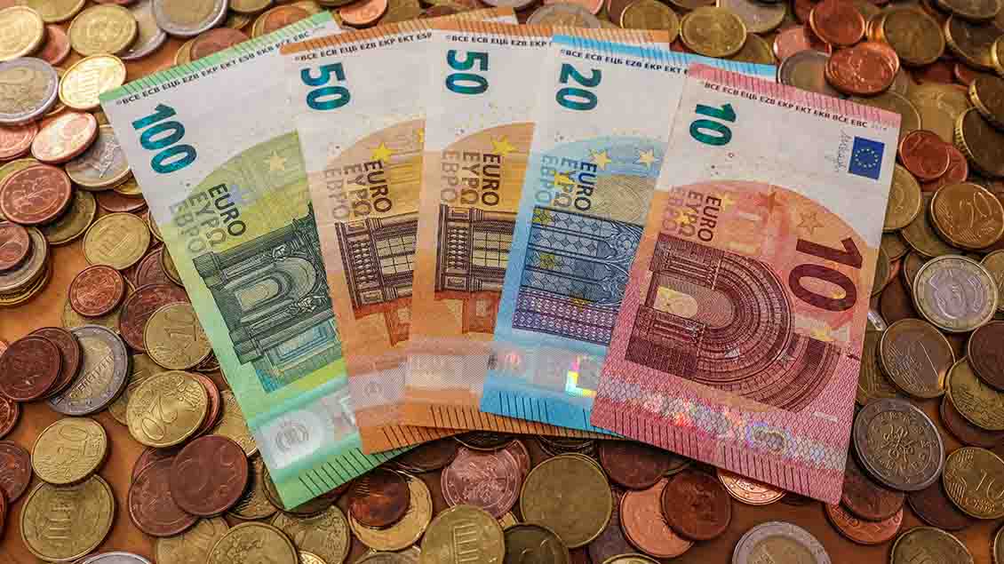Haufen von Euro-Münzen und Geldscheinen