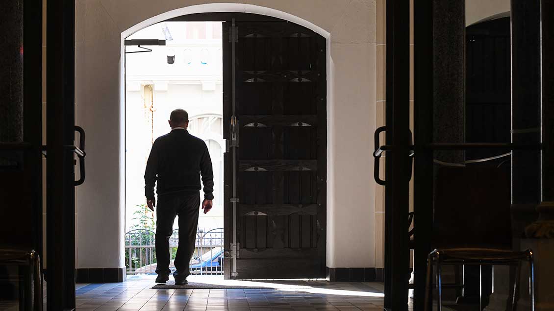 Ein Mann geht durch ein Portal aus einer Kirche heraus. Foto: Harald Oppitz (KNA)