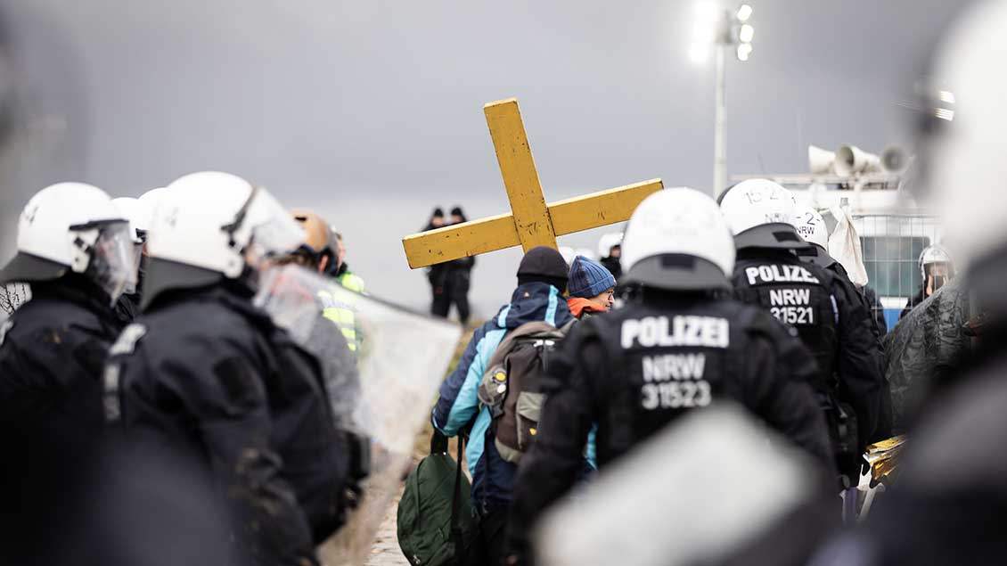 Eine Demonstrantin mit Kreuz umringt von Polizisten in Lützerath Foto: Lars Heidrich (Funke Foto Services / Imago)