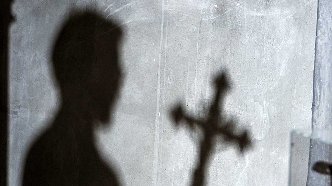 Schatten eines Mannes und eines Kreuzes Foto: Harald Oppitz (KNA)