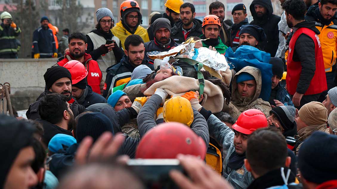 Retter bergen eine Frau aus den Trümmern eines beim Erdbeben in der Türkei zerstörten Hauses
