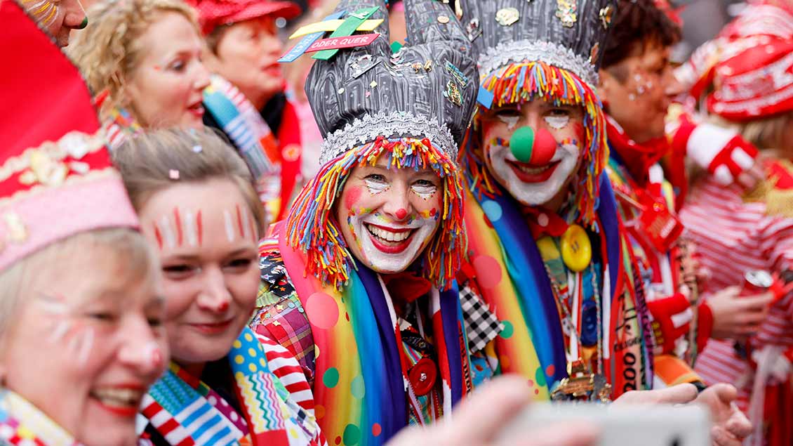 Lachende Karnevalisten am Straßenrand Foto: Christoph Hardt (Imago)