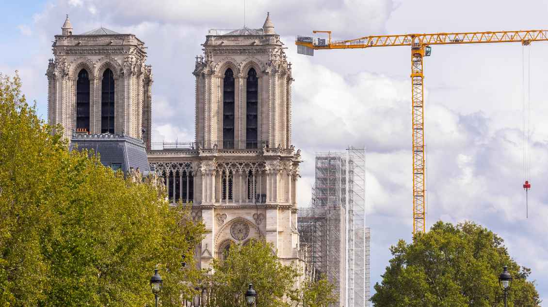 Die beiden Kirchtürme der Notre Dame. Rechts im Bild steht ein großer, gelber Baukran. Es ist bewölkt und die Bäume sind grün. Foto: Vincent Isorex (IP3press/imago)