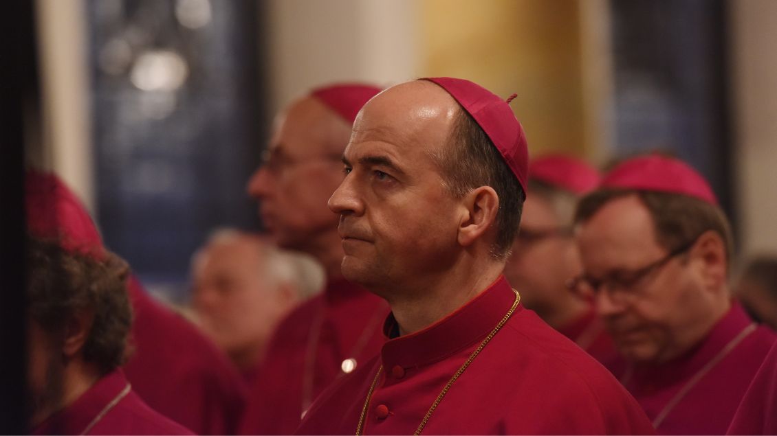 Bischof Franz Jung sitzt zwischen vielen Bischöfen