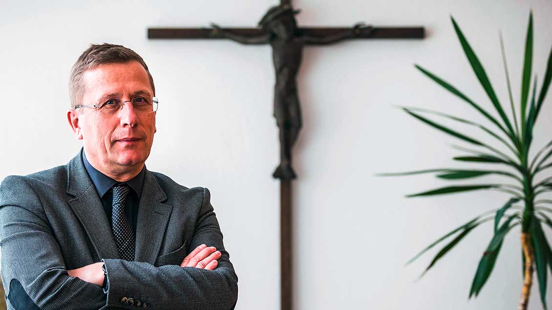 Thomas Schüller vor einem Kreuz Foto: Lars Berg (KNA)