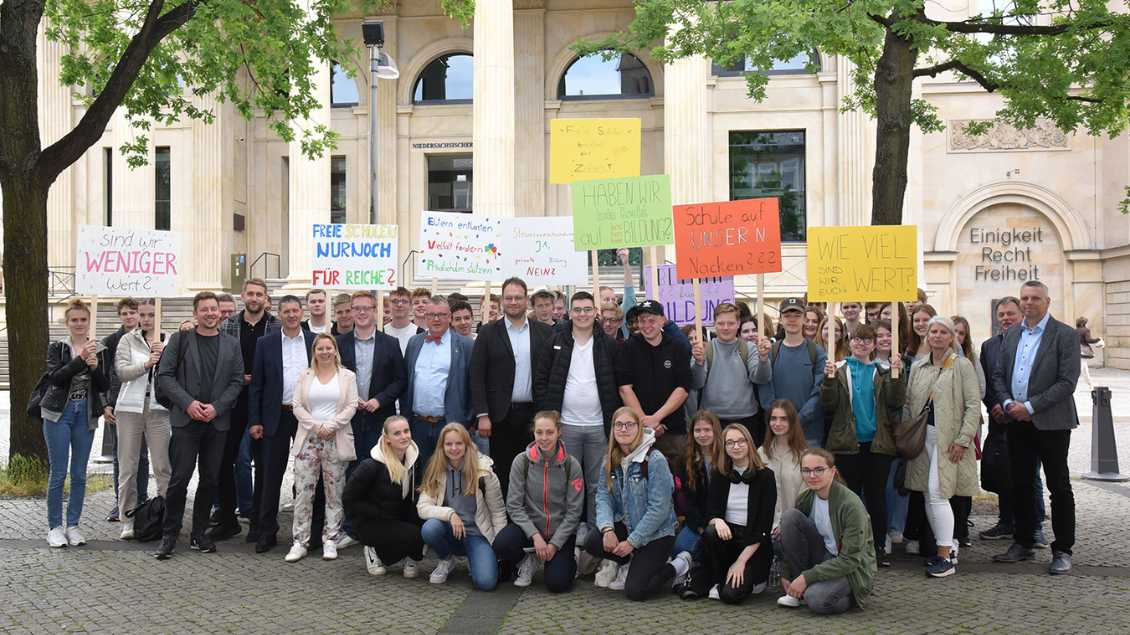 Schüler halten Plakate vor dem Niedersächsischen Landtag in die Höhe. Mit dabei stehen auch Abgeordnete. Foto: pd
