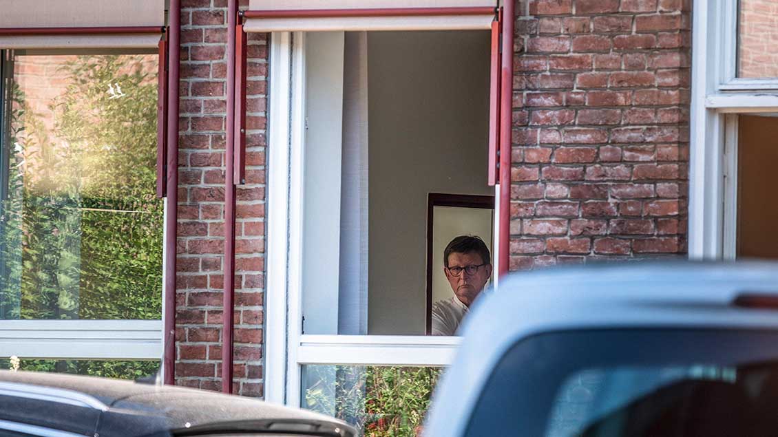 Kardinal Rainer Maria Woelki schaut durch ein Fenster des Bischofshauses