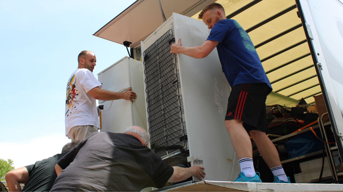 Betreuer fahren Kühlschränke auf der Hebebühne eines LKW´s herunter. Fotos: Paul Hintzke