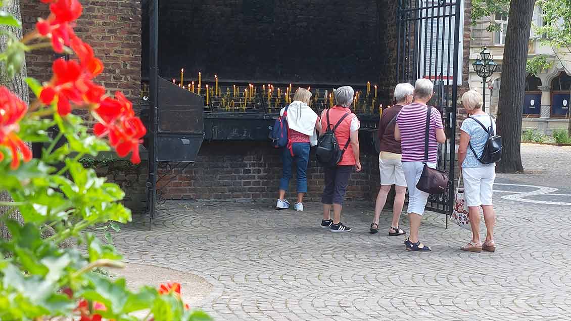An der Außenwand der Kerzenkapelle herrscht auch an den ruhigeren Tagen ein beständiges Kommen und Gehen. Wer Kevelaer besucht, entzündet eine Kerze. | Foto: Cordula Spangenberg