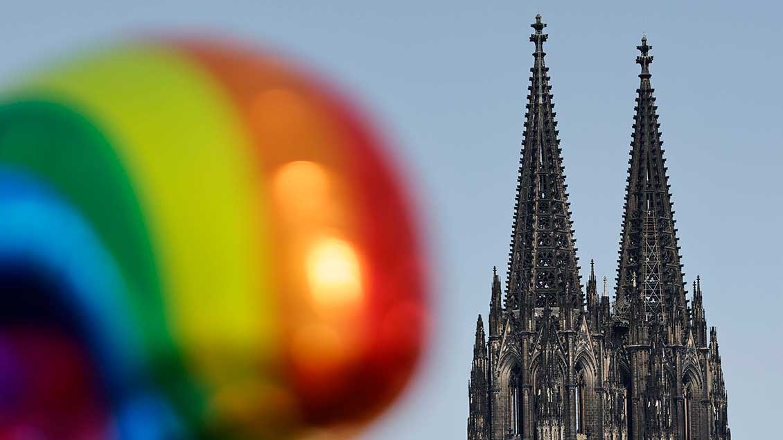 Regenbogen-Ballon vor Kölner Domturmspitzen