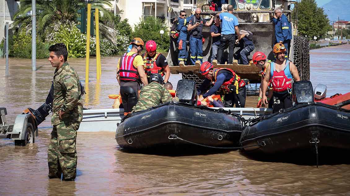 Helfer kämpfen sich in einem Schlauchboot durch das Hochwasser