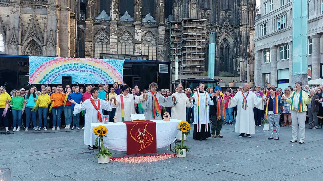 Seelsorgende mit Regenbogenstolen vor dem Kölner Dom