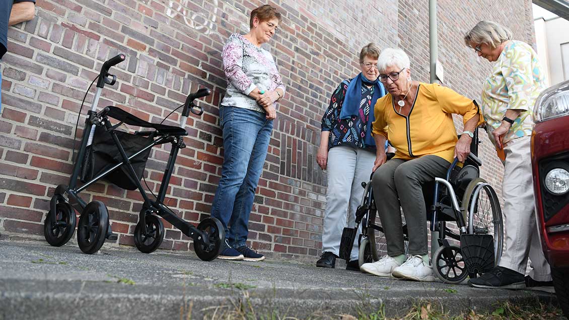 Bremsen anziehen vor dem Hinsetzen und Aufstehen: Martina Erwig-Kaul (rechts) und Andrea Jäger (Zweit von links) beobachten die Herausforderungen eines Rollstuhls.  | Foto: Michael Bönte