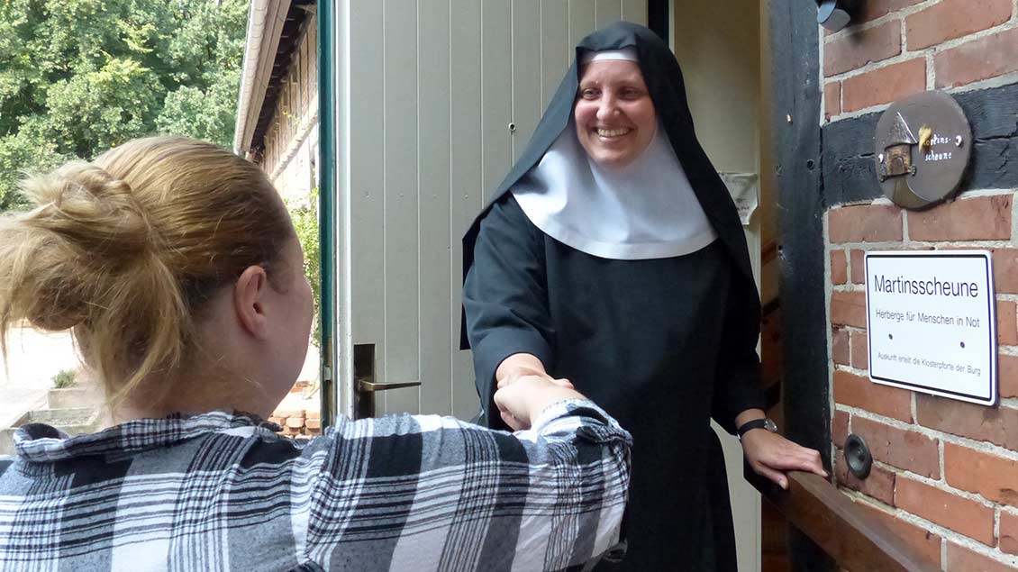 Schwester Johanna Wiese begrüßt einen Gast an der Pforte der Martinsscheune