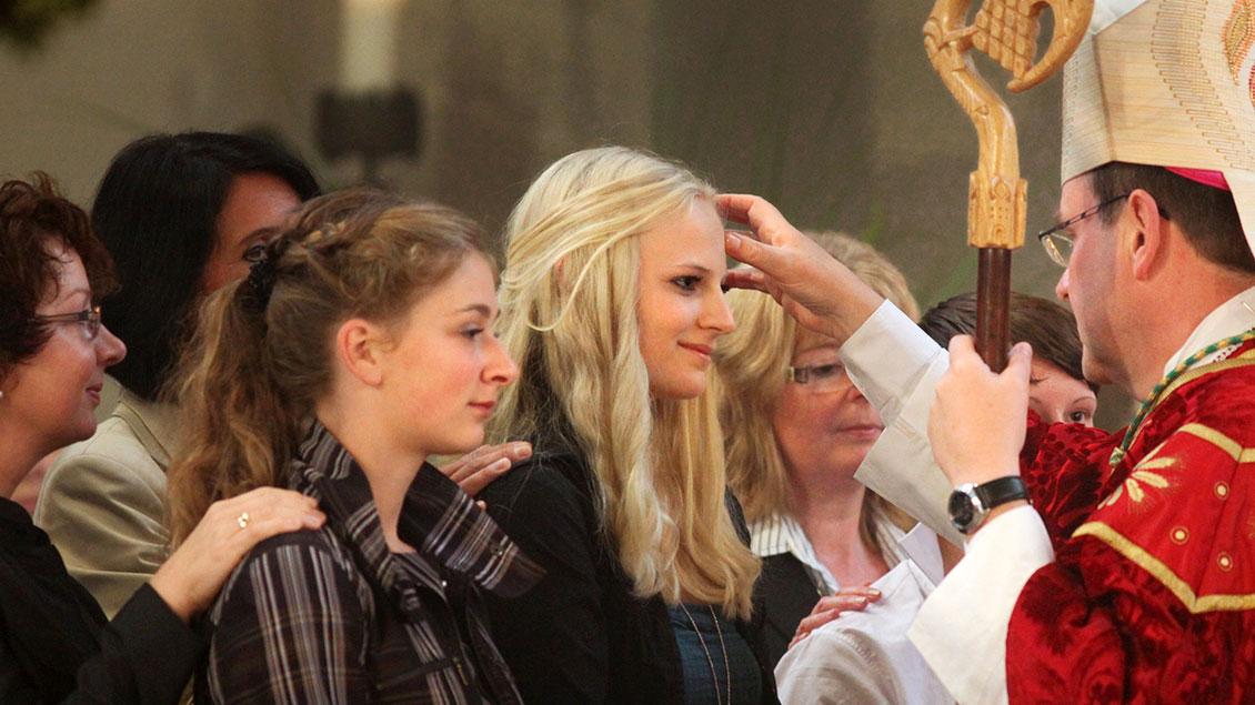 Jugendliche beim Empfang der Firmung durch Weihbischof Schepers